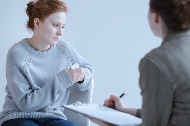 Sad,Girl,Holding,A,Tissue,And,Talking,To,Her,Therapist