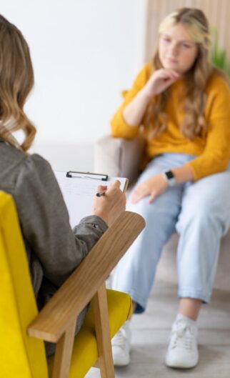 Teenage,Girl,On,Consultation,With,Psychotherapist.,Close-up,Of,Hand,With