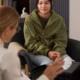 Vertical,Portrait,Of,Teenage,Girl,Listening,To,Therapist,In,Meeting